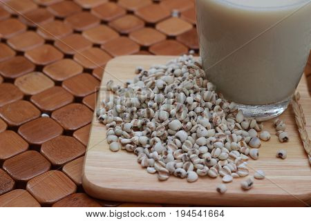 Coix lacryma-jobi, boiled in a glass on a brown background