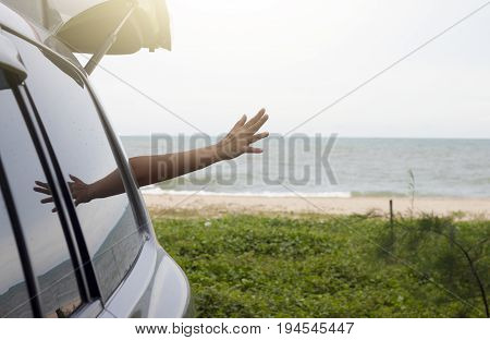 Show motion hand of black of car on the sand beach with Morning glory on the beach.