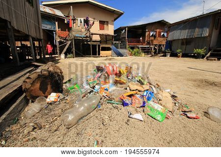 MABUL, MALAYSIA - CIRCA JULY 2017: Plastic pollution environmental proble. Plastic carrier bags, bottles and straws dumped by seaside fishing village