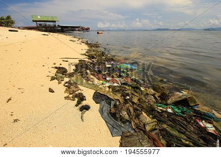 MABUL, MALAYSIA - CIRCA JULY 2017: Plastic pollution environmental proble. Plastic carrier bags, bottles and straws dumped by seaside fishing village
