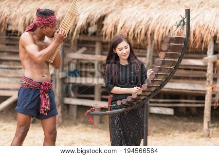 Asian beautiful girl are happy playing Pong Lang is a Thai musical instrument in summer at Countryside.