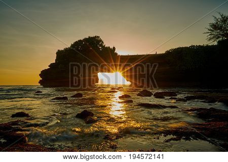 Scenic Sunset And Rays Of Sunlight Shines From Rock Hole At Tanah Lot In Bali Island Indonesia