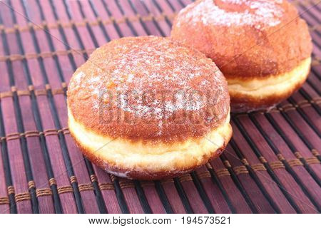 Homemade Doughnuts with Jelly filled and powdered sugar on Bamboo tablecloth. Selective focus