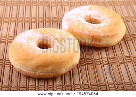 Homemade Doughnuts with Jelly filled and powdered sugar on Bamboo tablecloth. Selective focus