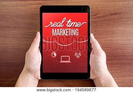 Two Hand Holding Tablet With Real Time Marketing And Icon On Screen At Dark Brown Table Top,digital