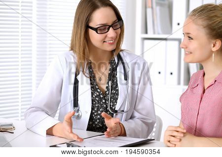 Doctor sitting near his patient and discussing confidental medical history.