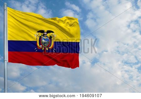 National flag of Ecuador on a flagpole in front of blue sky.