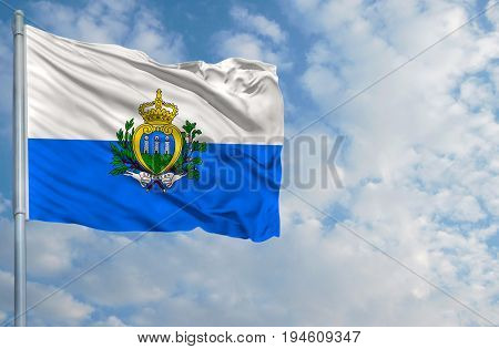 National flag of San marino on a flagpole in front of blue sky.