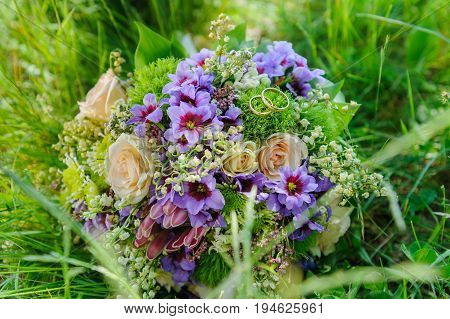 Beautiful summer wedding bouquet and wedding rings in flowers. Delicate bright flowers for girls