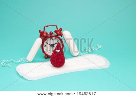 Red alarm clock dreamy smile crochet blood drop daily menstrual pad and tampons. Menstruation sanitary woman hygiene. Woman critical days gynecological menstruation cycle. Medical conception photo