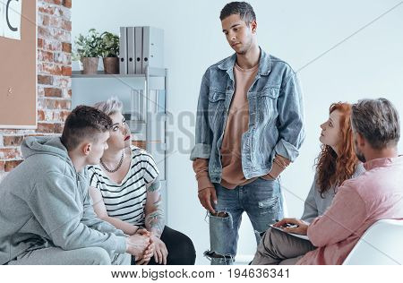 Teenager speaking to a group of contemporaries on therapy session