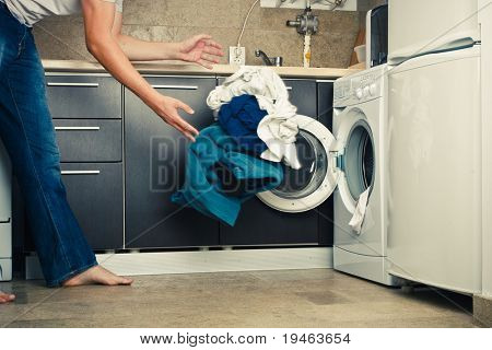 Concetto uomo gettando il suo bucato in lavatrice