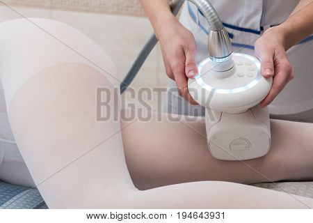 Woman in special white suit getting anti cellulite massage in a spa salon. LPG, and body contouring treatment in clinic. Lipomassage procedure on female body.