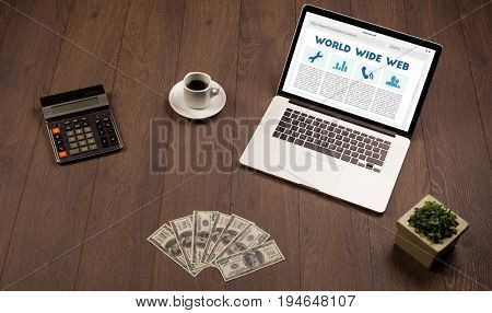 Laptop computer on wooden desk with office suplies