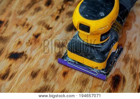 worker sander to sand wood Cleaning the board with polishing