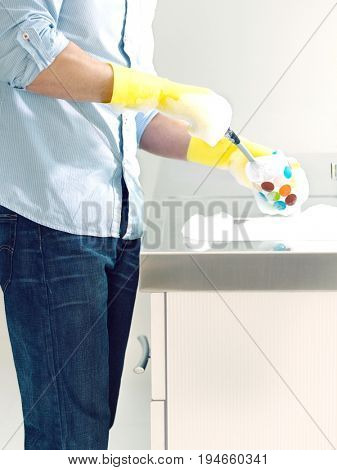 Side view of a midsection man doing washing up at kitchen sink