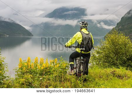 Mountain bike cyclist near fjord, summer Norway