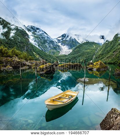 Fishing boat on a still lake in Norway and high mountains in background. Bondhusvatnet