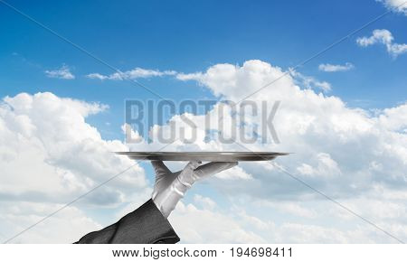 Butler hand in white glove presenting empty tray