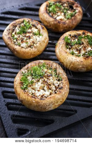 Traditional Italian Mushroom Caps stuffed with Feta as close-up on a grillage
