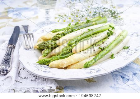 Boiled green and white Asparagus as top view on a plate 