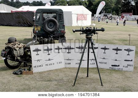 Sandhurst, Uk - 18Th June 2017: Vintage Toned Shot Of A Ww2 Rangefinder With Motorcycle And Aircraft