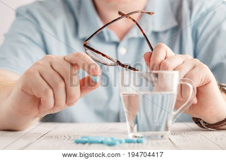 Man taking drugs. Drugs on one hand.