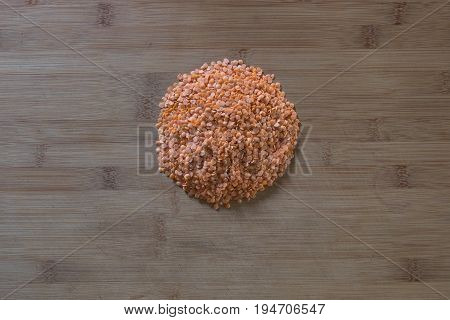 Red lentils in the form of a cirlcle on wooden cutting board