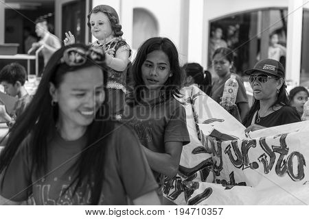 BORACAY, WESTERN VISAYAS, PHILIPPINES - JANUARY 11, 2015: Black and white picture of a girl holding Santo Nino statue at Ati-Atihan Festival at White Beach.