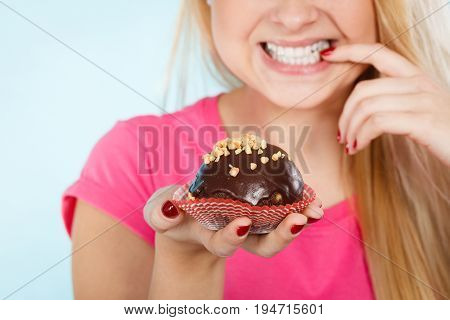 Woman Holding Chocolate Cupcake About To Bite