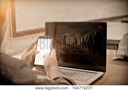 Double exposure hand business man working with smart phone and computer to work wirelessly. Press OK Trading smartphone and computer. Concept boundless business and technology flare light.selected focus.