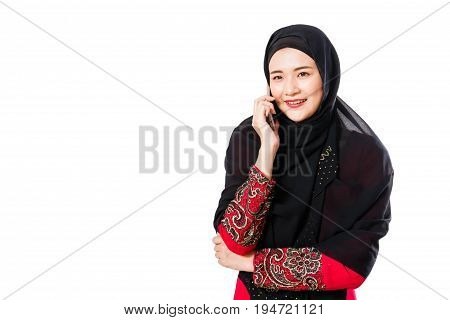Beautiful young muslim woman using moblie phone on a white background.