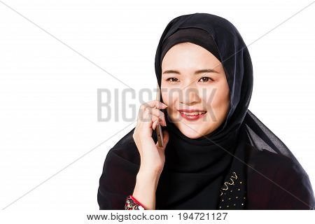Beautiful young muslim woman using moblie phone on a white background.