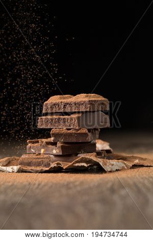 Broken chocolate on wooden table
