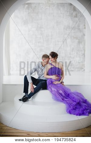 pregnant woman and man posing together in Studio, happy waiting