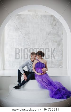 pregnant woman and man posing together in Studio, happy waiting