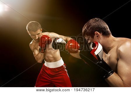 Two professional boxer boxing on black studio background.