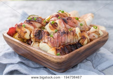 Grilled bacon wrapped haloumi cheese with vegetables and pita
