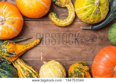 Autumn  frame from decorative Pumpkins over wooden background, top view