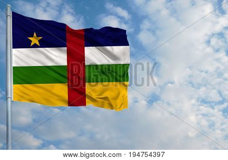 National flag of Central African republic on a flagpole in front of blue sky.