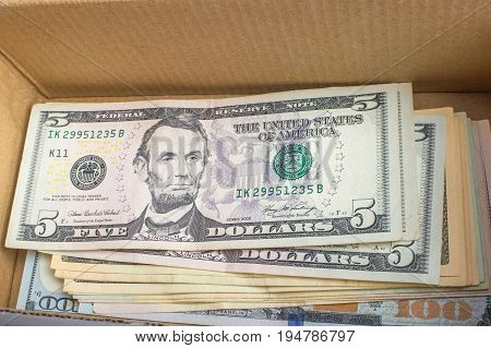 A pile of dollar bills lying in a box.