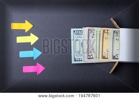 Arrows point to a stack of dollar bills looking out of the box. Increase in savings. Home safe. Business concept.