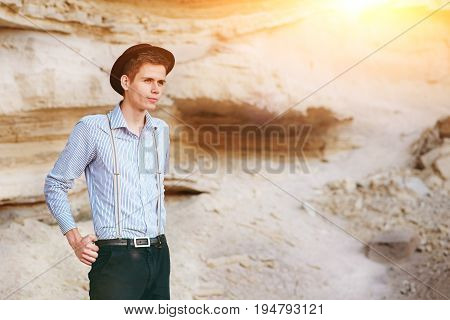 Stylish Attractive Man Stands In The Middle Of A Sand Quarry And Poses On The Camera
