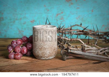 Communion table with crown of thorns, wine cup, grapes and nails