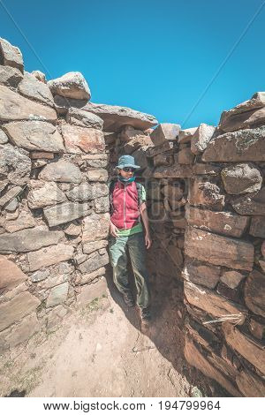 Tourist Exploring The Ancient Mysterious Inca Labyrinth-like Settlement, Called Chinkana, On The Isl