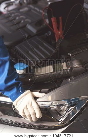 Like taking cars cardiogram. Nice scrupulous successful specialist performing comprehensive checkup and opening a bonnet for wiring up professional indicator