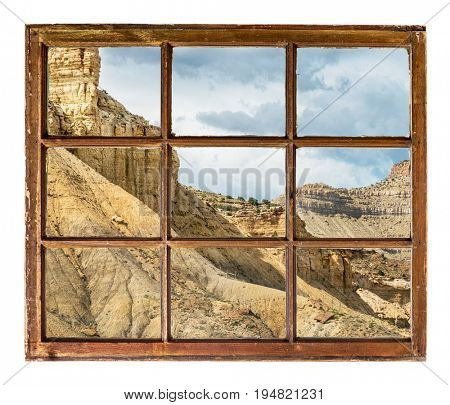 cliff, buttes and mesa of Book Cliffs in eastern Utah as seen  through vintage, grunge, sash window with dirty glass