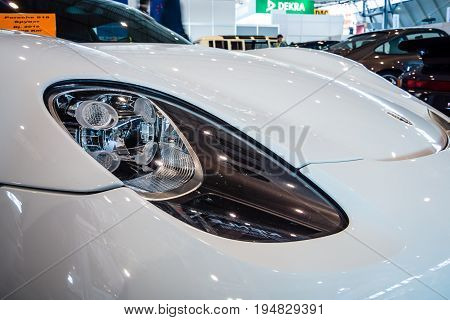 STUTTGART GERMANY - MARCH 17 2016: Headlamp of a mid-engined plug-in hybrid sports car Porsche 918 Spyder 2015. Close-up. Europe's greatest classic car exhibition 