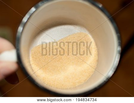 Heap Of Dry Small Gelatine Granules Or Powder In A Mug, Top View