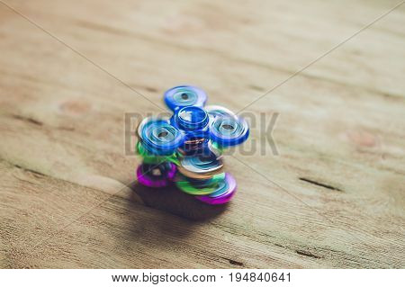 Colored Fidget Spinners Stress Relieving Toy On Wooden Background